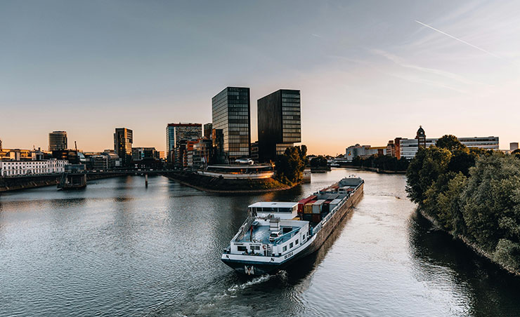 Düsseldorf und Containerschiff mit Bürogebäuden im Hintergrund